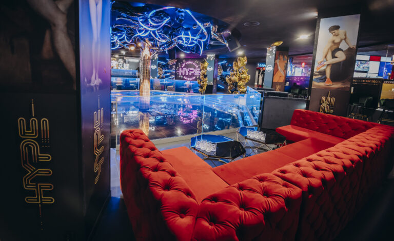 wnętrze Klubu Hype, sofa wzdłuż ściany, stoliki | Sofa Chesterfield w czerwonym welurze w Klubie Hype w Szczecinie