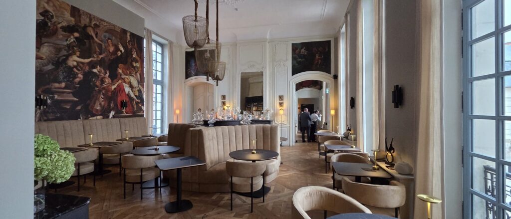 Strefa lounge z sofami tapicerowanymi i freskiem w Hôtel Royal Beaulaincourt