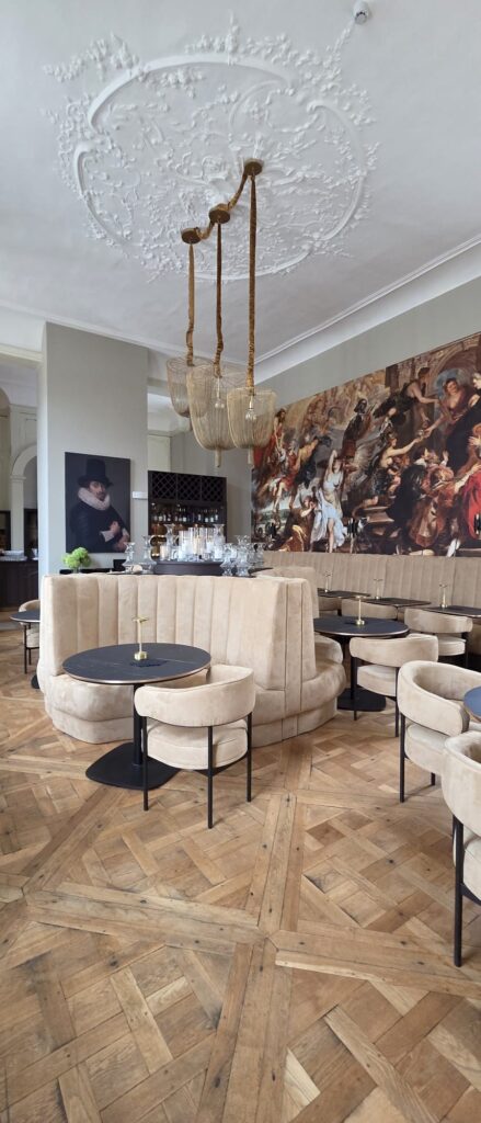 Okrągła loża tapicerowana pod barokowym freskiem w restauracji Hôtel Royal Beaulaincourt