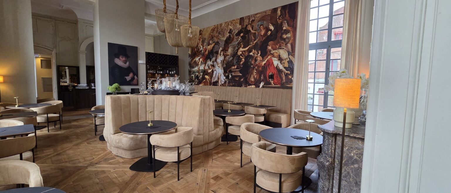 Okrągła sofa restauracyjna tapicerowana na wymiar w Hôtel Royal Beaulaincourt, w tle fresk