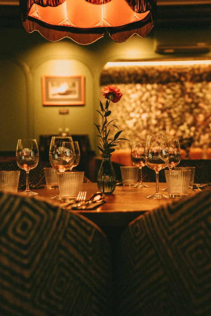 Krzesła tapicerowane we wzorzystej tkaninie przy okrągłym stole w restauracji Restbotanica w Katowicach
