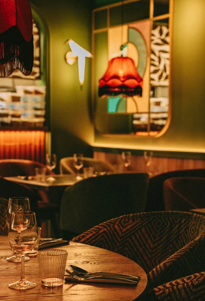 Detal oparcia krzesła tapicerowanego we wzorzystej tkaninie, nakryty stół w restauracji Restbotanica w Katowicach