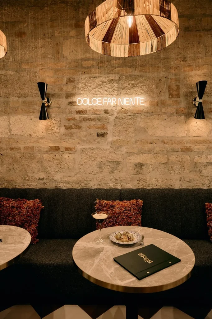 Ciemna loża tapicerowana na wymiar przy kamiennej ścianie w kameralnej sali restauracji w Budapeszcie