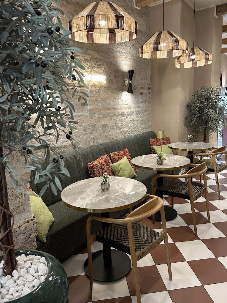 Loża tapicerowana na wymiar z okrągłymi marmurowymi stolikami w restauracji w Budapeszcie