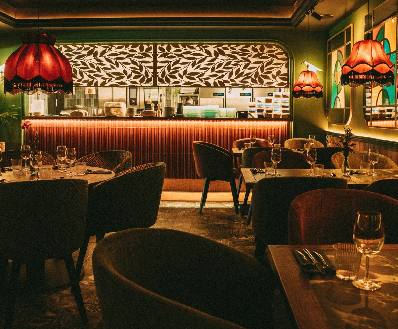 ala restauracji Restbotanica w Katowicach z sofami tapicerowanymi na wymiar i krzesłami przy otwartej kuchni