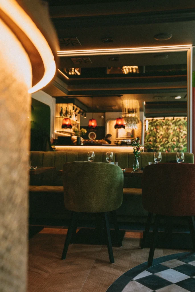 Prosta sofa Paris na wymiar w zielonej tapicerce, biegnąca wzdłuż baru w restauracji Restbotanica w Katowicach