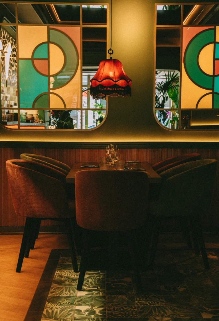 cztery krzesła wokół stołu, witraże w tle | Krzesła 121 wokół czteroosobowego stołu w sali restauracyjnej