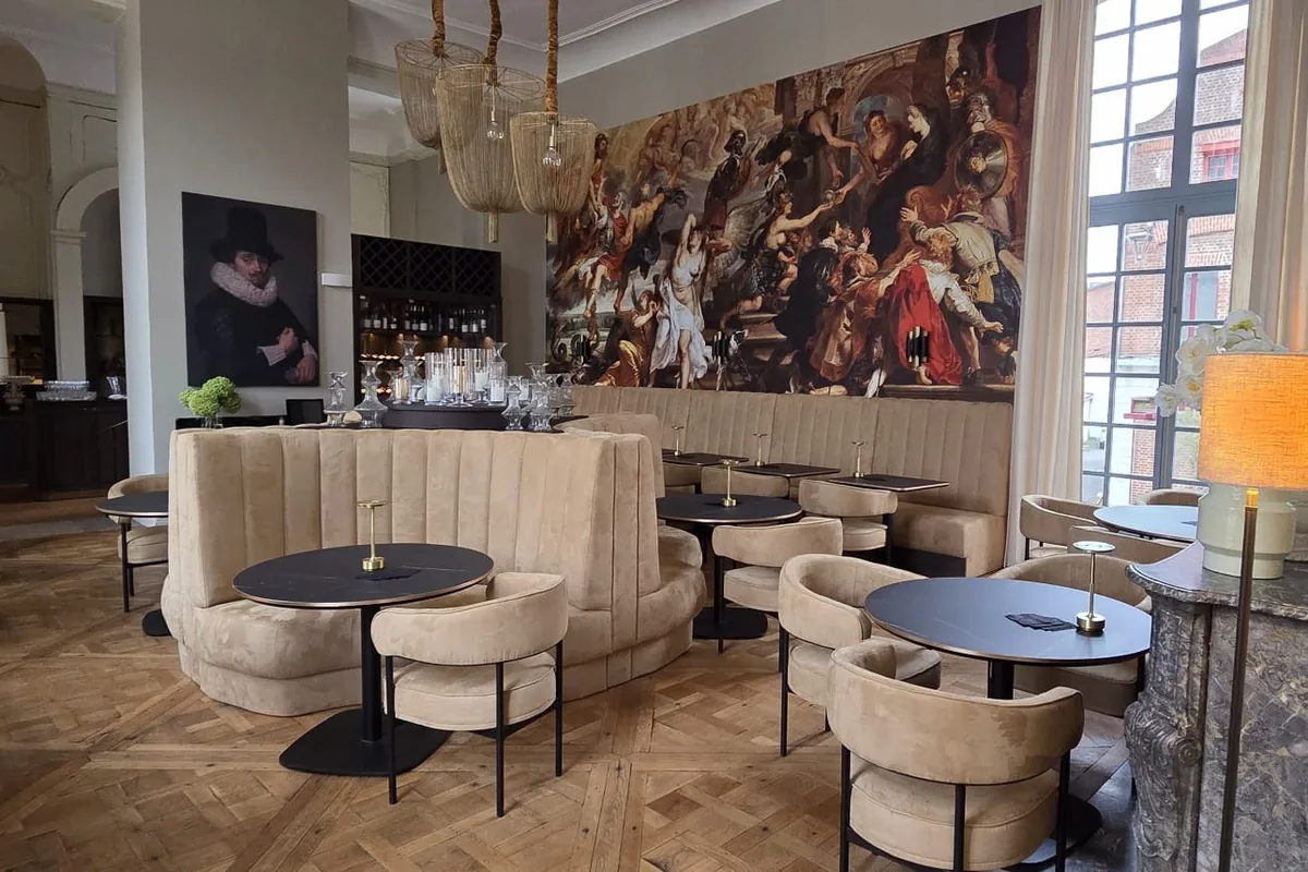 Okrągła sofa tapicerowana i krzesła w sali restauracyjnej Hôtel Royal Beaulaincourt we Francji