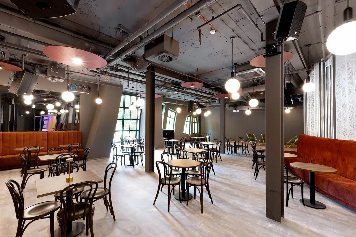 Sala food hallu w Krzywym Domku w Sopocie z lożami tapicerowanymi pod ścianami